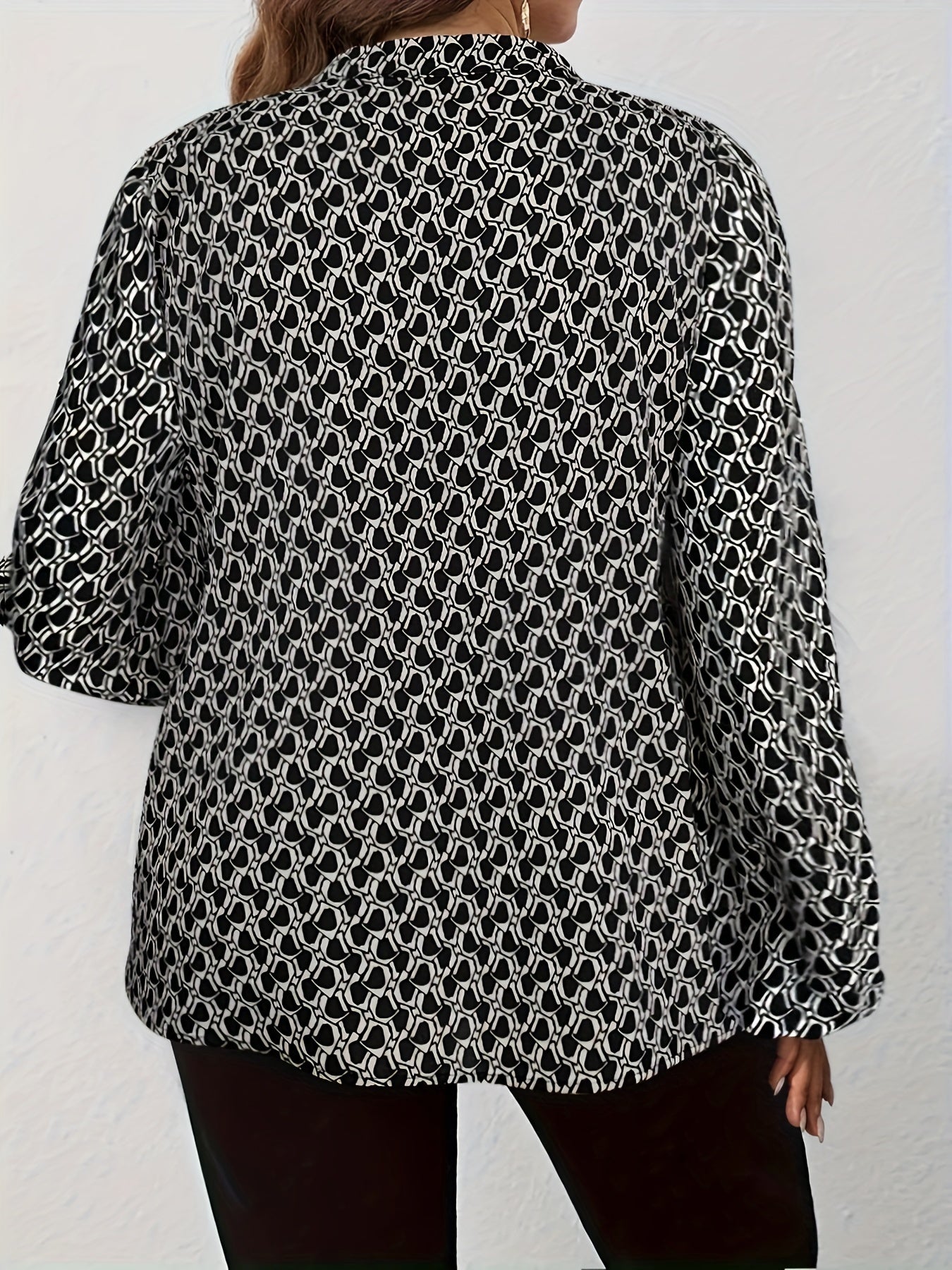 Loose-fitting plus size women's fashion shirt with wide sleeves and V-neck, featuring a stylish print to create a slimming effect.